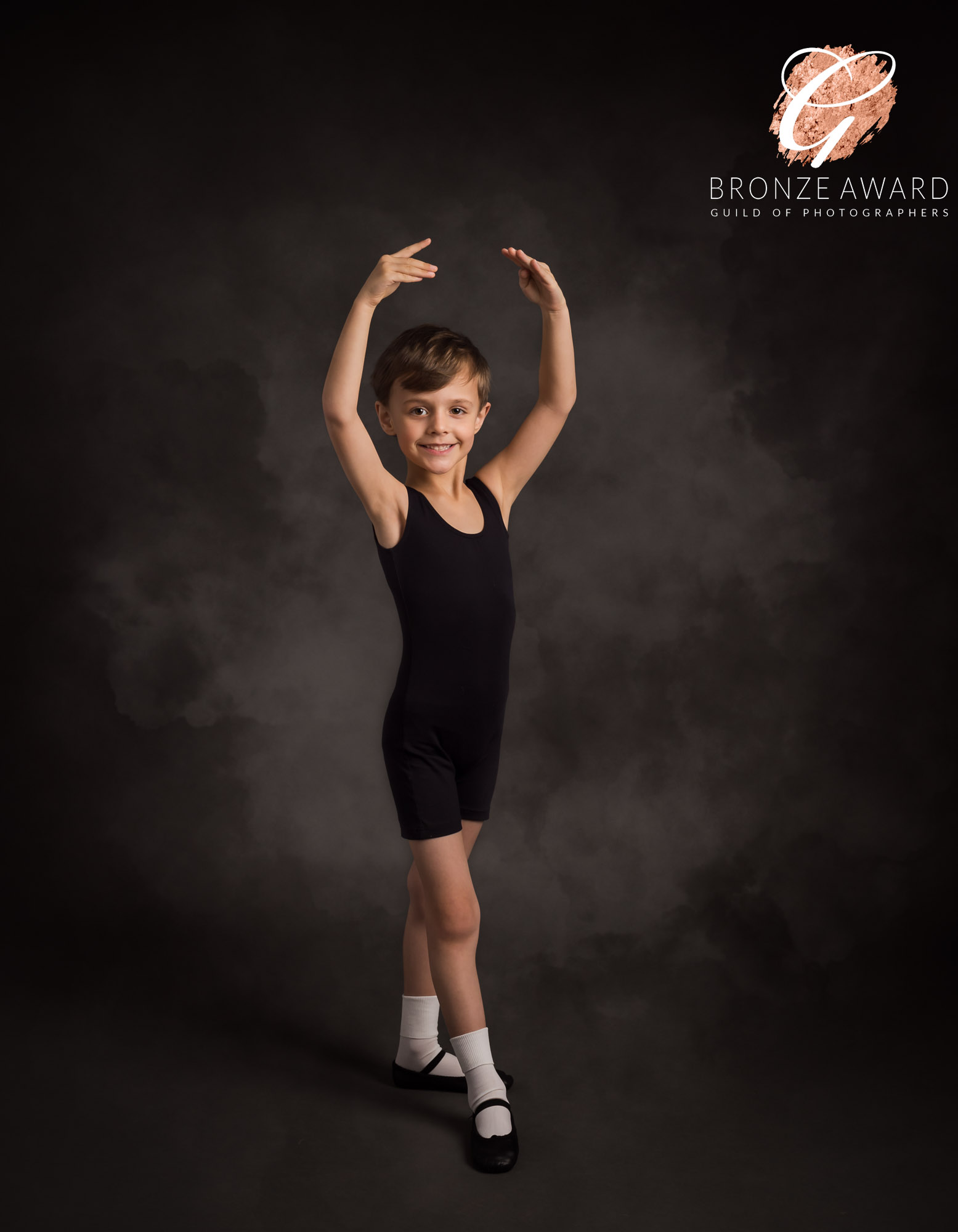 boy showing a ballet position wearing black leotard