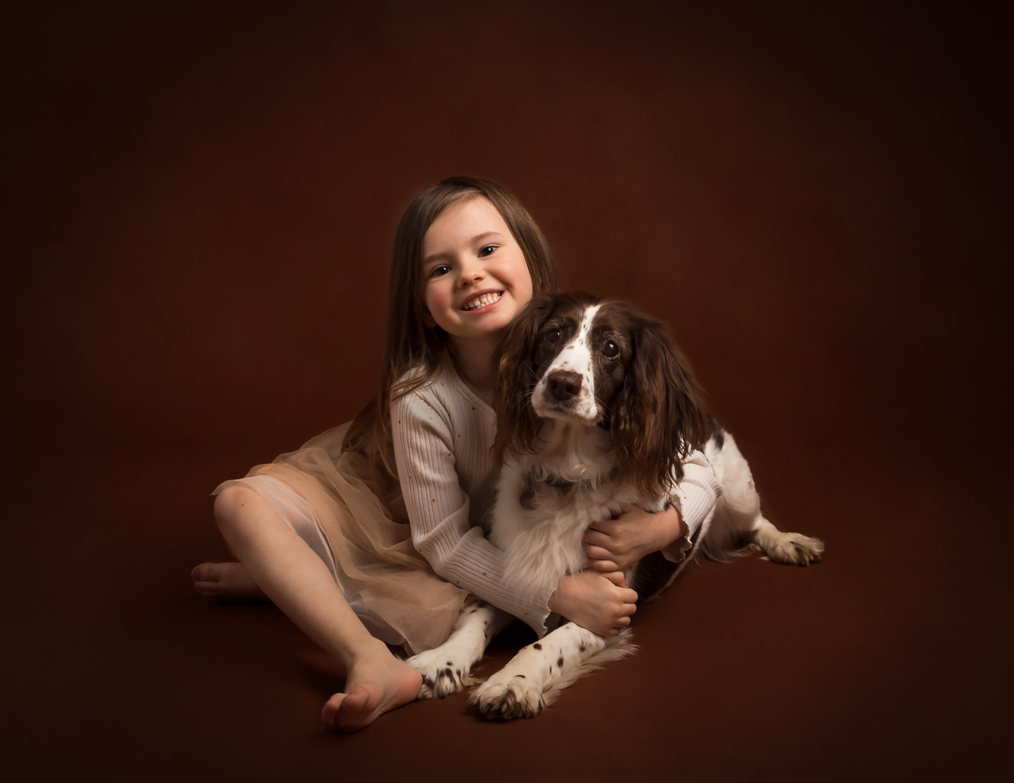 Girl smiling sat with pet dog