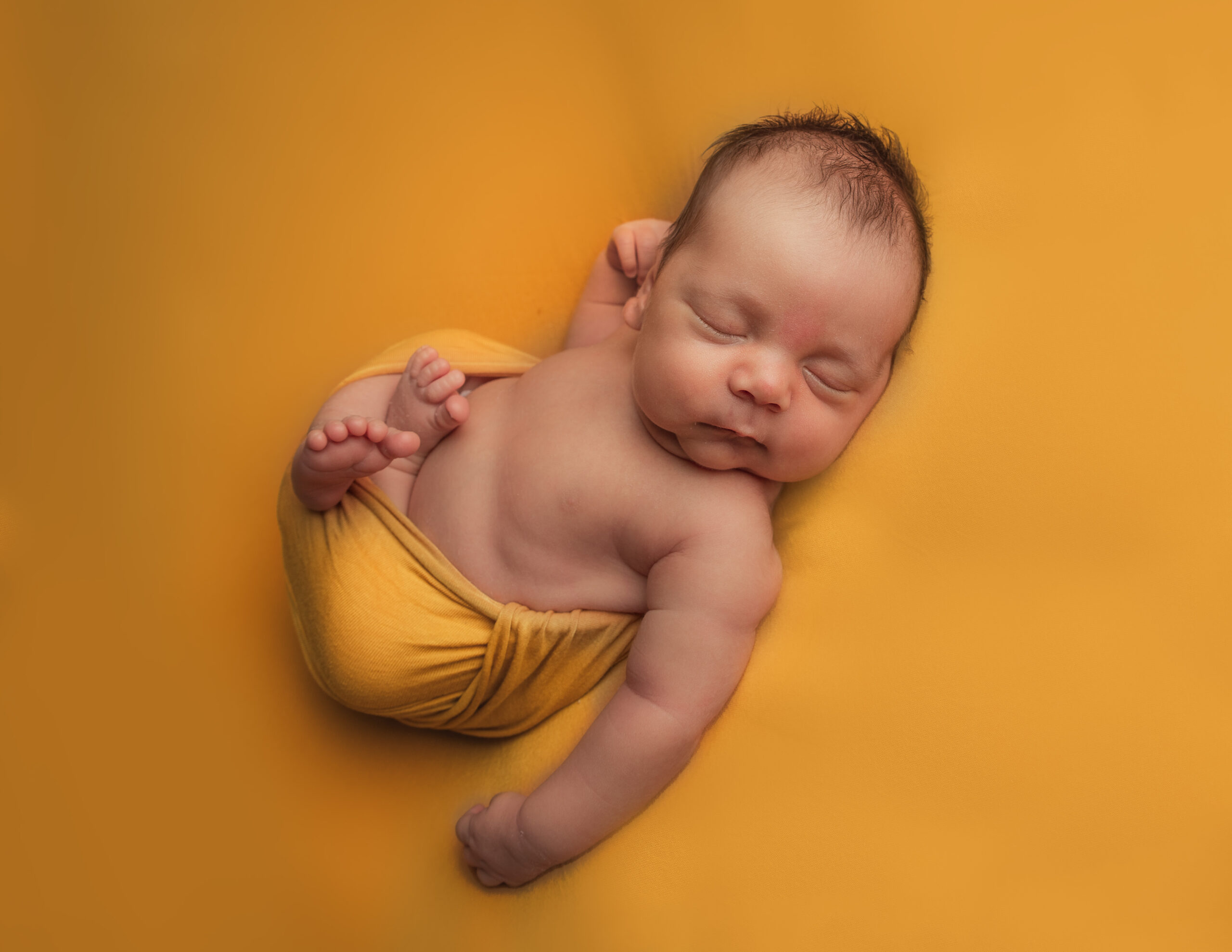 newborn photo shoot boy dressed in autumn colours in a bucket by Newborn Photographer in Hampshire